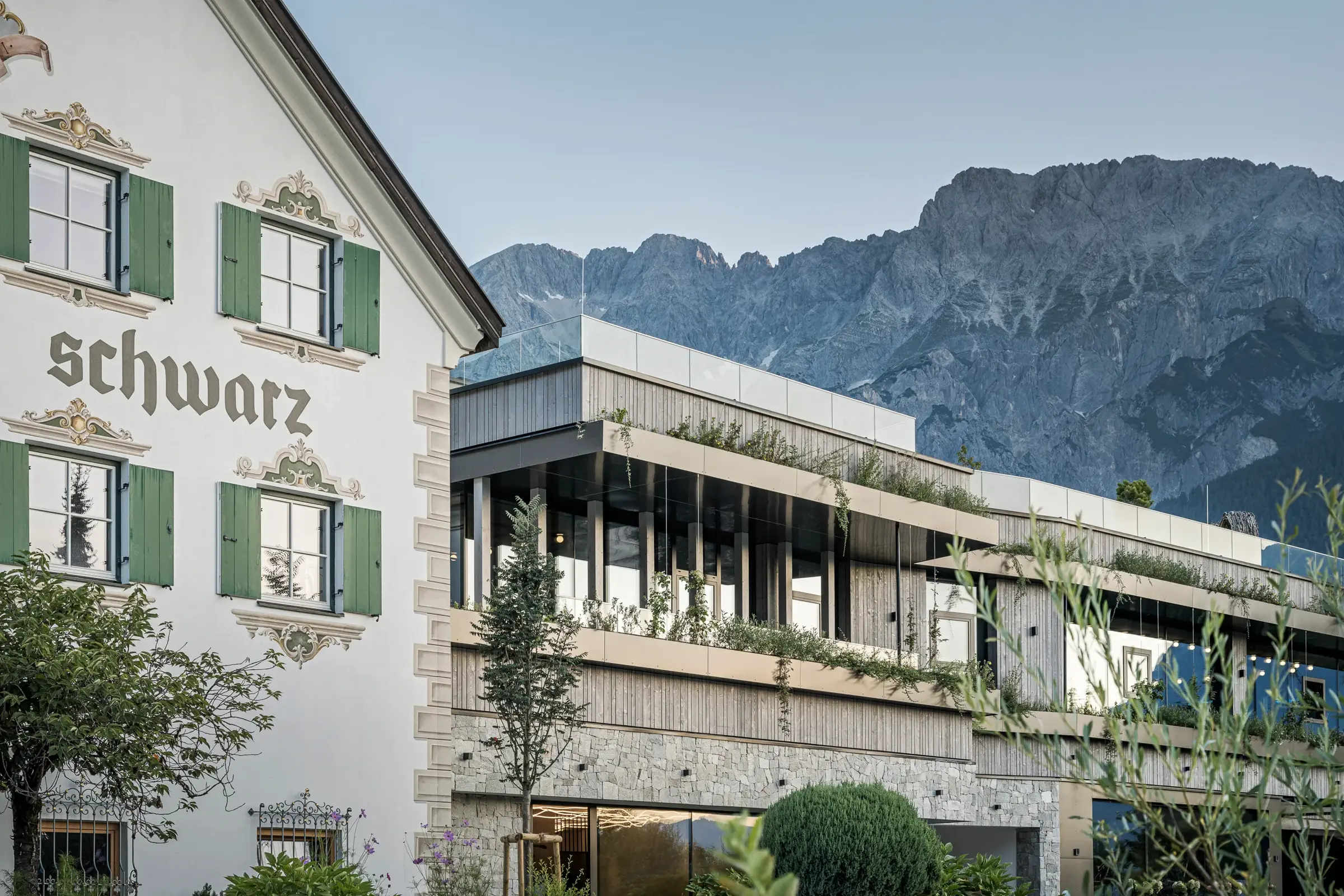 Außenansicht des Alpenresort Schwarz mit historischem Stammhaus vor dem Mieminger Gebirge – 5-Sterne Hotel in Tirol