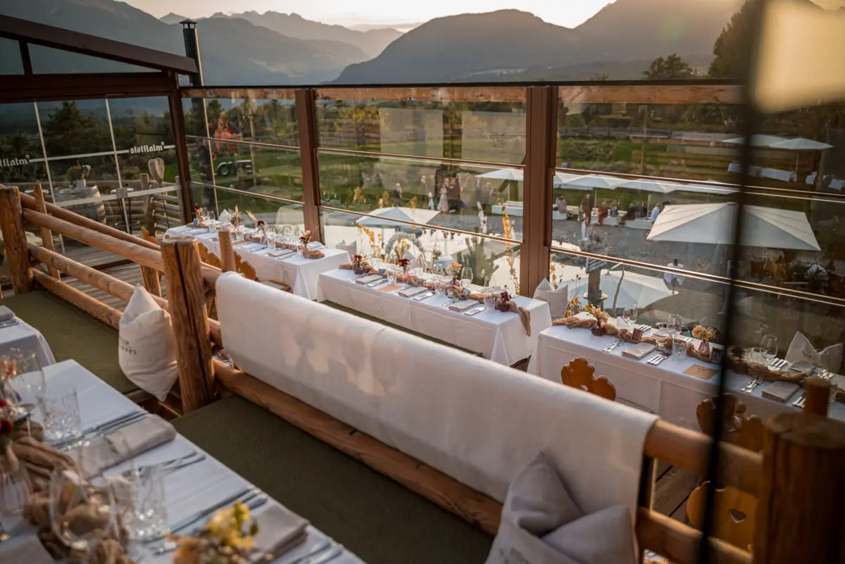 Festlich gedeckte Hochzeitstafeln auf der Panoramaterrasse der Stöttlalm mit Bergblick