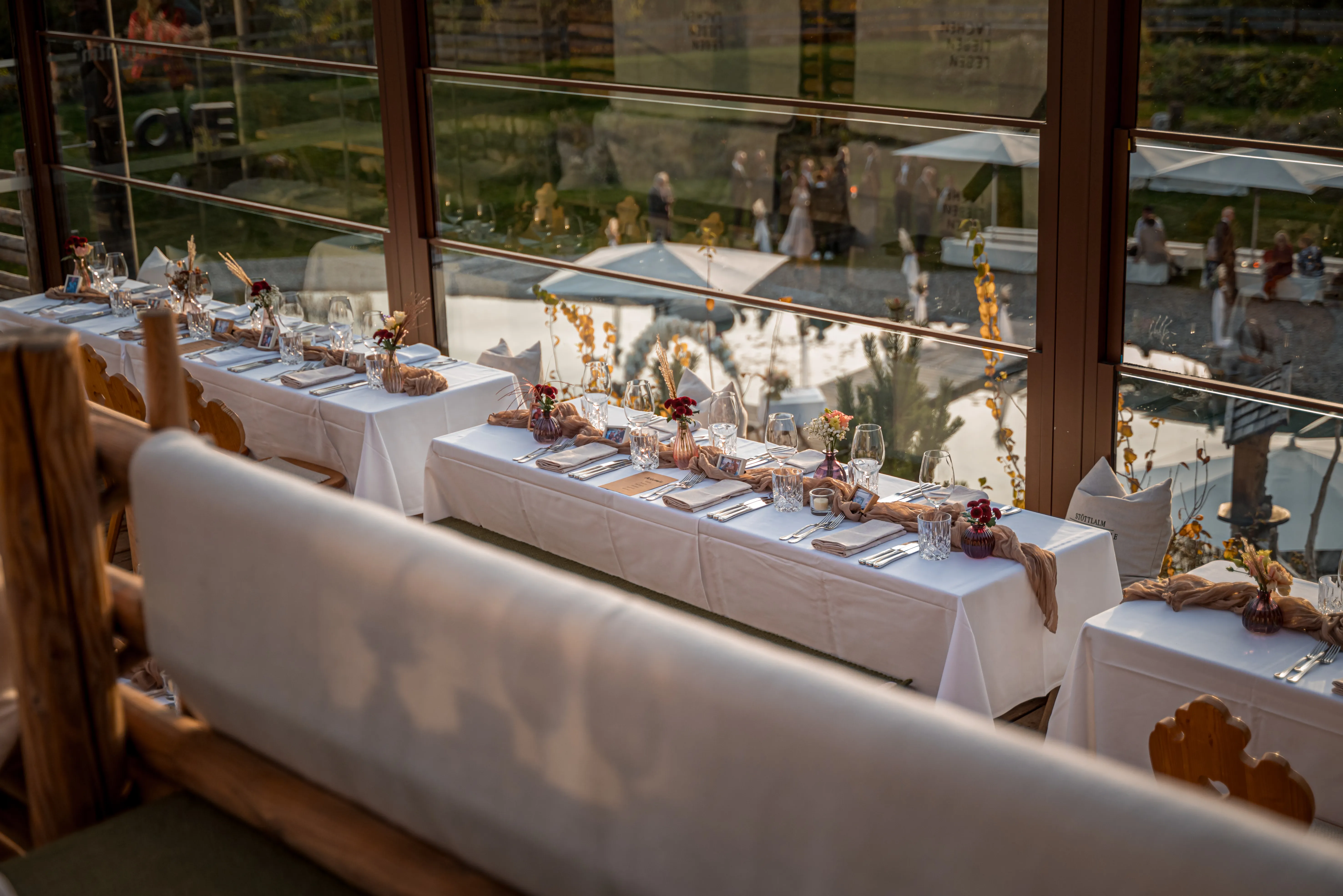 Festlich gedeckte Tafeln auf der verglasten Panoramaterrasse der Stöttlalm – Almhütte für Feiern und Events in Tirol